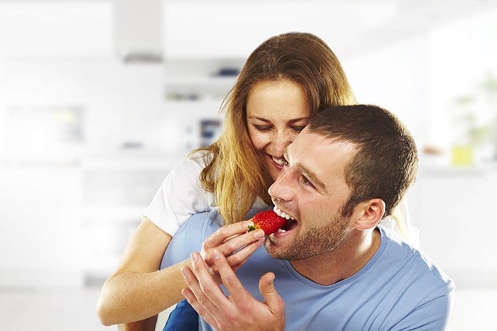 happy couple eating strawberries