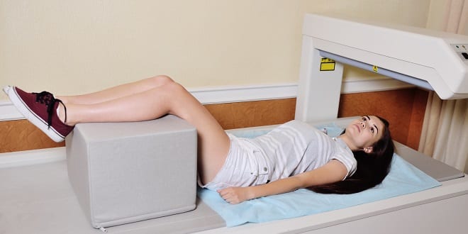 young pretty girl on examination in a modern clinic by densitometry young girl on examination in a modern clinic by densitometry