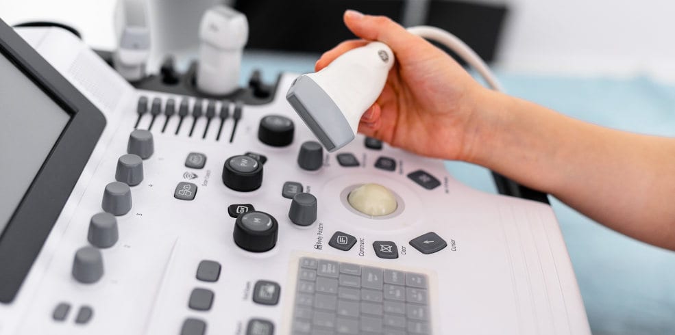 Ultrasound sensor of modern ultrasonic scanner in young woman doctor's hands preparing for a device scan. Helthcare concept Ultrasound sensor of modern ultrasonic scanner in young woman doctor's hands preparing for a device scan. Helthcare concept