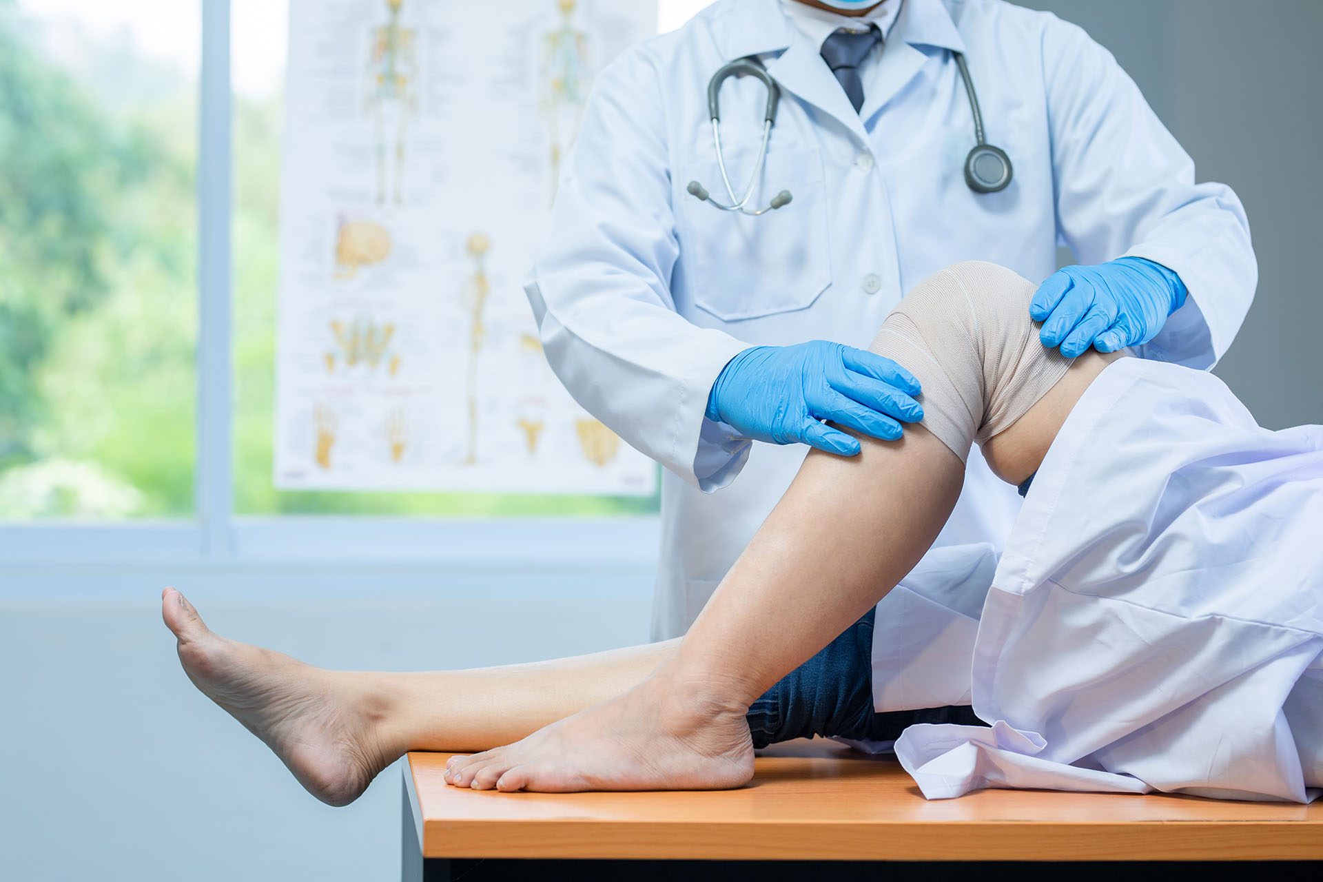 close-up-hand-wear-medical-gloves-doctor-examining-head-patient-with-knee-problems-clinic